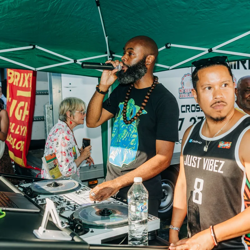 An MC on the microphone beside a DJ at the decks during the rally.